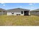 A spacious backyard with green grass featuring a relaxing hammock stand, ideal for outdoor leisure at 105 Blue Alice Spring Ct, Ruskin, FL 33570