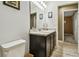 Stylish bathroom featuring dark wood vanity, modern fixtures and wood-look floors at 105 Blue Alice Spring Ct, Ruskin, FL 33570