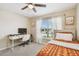 Bright bedroom with a ceiling fan, desk and a large window for natural light at 105 Blue Alice Spring Ct, Ruskin, FL 33570