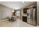 Dining area with a modern chandelier, table with seating, and stainless steel refrigerator at 105 Blue Alice Spring Ct, Ruskin, FL 33570