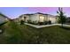 Charming home with lush landscaping, featuring a well-manicured lawn and garden beds, highlighted by walkway lighting at 105 Blue Alice Spring Ct, Ruskin, FL 33570