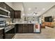 Modern kitchen with stainless steel appliances, dark cabinetry, and open layout to the living room at 105 Blue Alice Spring Ct, Ruskin, FL 33570