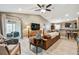 Open-concept living room with comfortable seating, a modern ceiling fan, and a sliding door to the patio at 105 Blue Alice Spring Ct, Ruskin, FL 33570