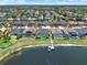 Stunning aerial view of houses with screened pools and a private dock and boat on the lake at 11743 Lake Lucaya Dr, Riverview, FL 33579
