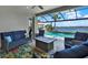 Relaxing screened patio with comfortable seating, a fire pit, and a view of the pool and waterway at 11743 Lake Lucaya Dr, Riverview, FL 33579