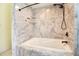 Bathroom boasts a tub with marble surround, rainfall shower head, and built-in shelving at 12140 Capri S Cir, Treasure Island, FL 33706