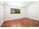 Bedroom with hardwood floors, large window, and closet with bi-fold door at 12140 Capri S Cir, Treasure Island, FL 33706