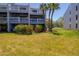 Three-story condo building with multiple balconies and tropical landscaping at 12140 Capri S Cir, Treasure Island, FL 33706