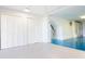 Bright garage with white louvered closet doors, painted blue floors, and white walls at 12140 Capri S Cir, Treasure Island, FL 33706