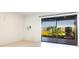 Enclosed lanai featuring tiled floors, sliding glass doors with a view of community landscaping and a building in the distance at 12140 Capri S Cir, Treasure Island, FL 33706