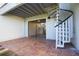 Brick patio with a spiral staircase, leading to upper level; sliding glass doors open to an interior room at 12140 Capri S Cir, Treasure Island, FL 33706
