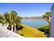 Water view from balcony showcasing blue water, condos, palm trees, and green grass at 12140 Capri S Cir, Treasure Island, FL 33706