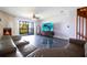 Spacious living room with a cozy fireplace, ceiling fan, and balcony access showcasing the serene outdoor views at 12140 Capri S Cir, Treasure Island, FL 33706