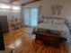 Spacious bedroom with wood floors, vaulted ceiling, and a comfortable bed, a table and chairs, and a chest at 126 Philadelphia Blvd # 10, Palm Harbor, FL 34684