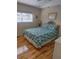 Comfortable bedroom with wood floors, a large window, and a stylish bed with a tropical print at 126 Philadelphia Blvd # 10, Palm Harbor, FL 34684