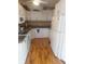 Bright kitchen featuring wood floors, white cabinets and appliances, and dark countertops at 126 Philadelphia Blvd # 10, Palm Harbor, FL 34684