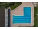 Aerial view of the community pool, with bright blue water, surrounding sun deck and lounge chairs at 130 Woodcutter Ln, Palm Harbor, FL 34683