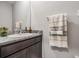 Powder room featuring dark wood cabinets, granite countertops, a decorative mirror, and neutral towels at 13061 Brookside Moss Dr, Riverview, FL 33579