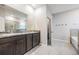 Bathroom featuring double sink vanity with granite countertop, tiled flooring, and separate shower and tub at 13061 Brookside Moss Dr, Riverview, FL 33579