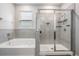 Bright bathroom featuring a shower with glass doors, a soaking tub, and gray tile surround at 13061 Brookside Moss Dr, Riverview, FL 33579