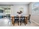 Bright dining area with a wooden table, black chairs and sliding glass doors to the backyard at 13061 Brookside Moss Dr, Riverview, FL 33579