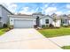 Charming one-story home featuring a well-maintained lawn and a two-car garage at 13061 Brookside Moss Dr, Riverview, FL 33579