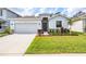 Well-manicured front yard featuring lush green grass and colorful landscaping around the home at 13061 Brookside Moss Dr, Riverview, FL 33579