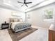 Serene main bedroom featuring a tray ceiling, ceiling fan and a neutral color palette at 13061 Brookside Moss Dr, Riverview, FL 33579