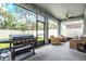 Screened-in patio featuring a Blackstone grill, wicker furniture, and views of the fenced backyard at 13061 Brookside Moss Dr, Riverview, FL 33579