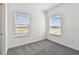 Cozy bedroom with carpet flooring and two windows at 13631 Sunlight Meadow Dr, Riverview, FL 33578