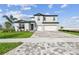 Two-story home featuring a 3 car garage, brick paver driveway, and a blue front door at 13631 Sunlight Meadow Dr, Riverview, FL 33578