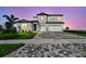 Beautiful two-story home featuring a brick paver driveway, lush landscaping, and a front entry two-car garage at 13631 Sunlight Meadow Dr, Riverview, FL 33578