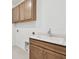 Laundry room includes wood cabinets and a sink with countertop at 13631 Sunlight Meadow Dr, Riverview, FL 33578