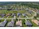 A stunning aerial view of the property nestled in a lush, green neighborhood with a nearby golf course at 13805 Carryback Dr, Dade City, FL 33525