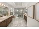 Bright primary bathroom featuring double vanity, soaking tub, and tiled walk-in shower at 13805 Carryback Dr, Dade City, FL 33525