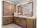 Bathroom vanity with a light countertop, cabinets, mirror, and wall-mounted lighting at 13805 Carryback Dr, Dade City, FL 33525
