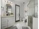 Bright bathroom features white marble flooring, a walk-in shower, a modern vanity, and window shutters at 13805 Carryback Dr, Dade City, FL 33525