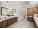 Bathroom with double vanity, large mirror, great storage, and marble floors at 13805 Carryback Dr, Dade City, FL 33525