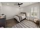 Well-lit bedroom featuring a ceiling fan, a comfy bed, nightstand and shuttered windows at 13805 Carryback Dr, Dade City, FL 33525