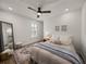 Cozy bedroom features a plush bed with soft linens, ceiling fan, wood-look floors, and window with plantation shutters at 13805 Carryback Dr, Dade City, FL 33525