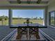 Covered patio featuring outdoor dining with a table and chairs, overlooking the spacious green backyard at 13805 Carryback Dr, Dade City, FL 33525