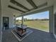 Relaxing covered patio features an outdoor dining area and expansive backyard views with a brick paved floor at 13805 Carryback Dr, Dade City, FL 33525