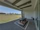 An open covered patio area with a table and chairs, perfect for outdoor dining and enjoying the scenic views at 13805 Carryback Dr, Dade City, FL 33525