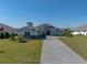 A charming home with a paved driveway, well-kept lawn, and stylish stone detailing on the exterior at 13805 Carryback Dr, Dade City, FL 33525