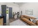 Home gym featuring workout equipment and a modern brown couch at 13805 Carryback Dr, Dade City, FL 33525