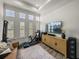 Bright home gym featuring workout equipment, a modern brown couch, and a textured rug at 13805 Carryback Dr, Dade City, FL 33525