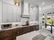 Bright kitchen with custom cabinets, modern appliances, marble countertops, and backyard views at 13805 Carryback Dr, Dade City, FL 33525