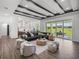 Open-concept living area with wood floors, ample seating, and sliding glass doors leading to the outdoor space at 13805 Carryback Dr, Dade City, FL 33525