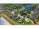 Aerial view of neighborhood homes with backyard views, a pond and blue skies at 14417 Barley Field Dr, Wimauma, FL 33598