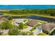 Lovely homes with manicured lawns beside a tranquil pond and serene tree line from above at 14417 Barley Field Dr, Wimauma, FL 33598